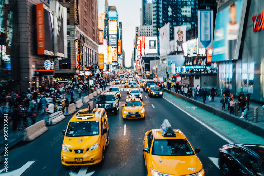 Fototapeta Efekt rozmycia ruchu, Times Square z oświetlonymi budynkami i reklamami na zatłoczonych ulicach i żółtych taksówkach dla turystów transportowych, centrum Nowego Jorku z ruchliwym ruchem i poruszającymi się taksówkami