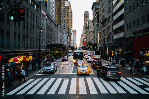 Canvas Print Big city life with crowded street and taxi cars on road controlling by traffic l