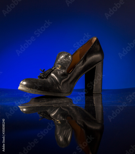 Women's shoes on a beautiful blue background and a black mirror surface