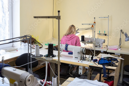 a room with sewing equipment and one female employee