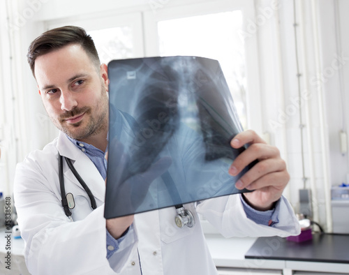 Doctor holding x-ray of lungs photo