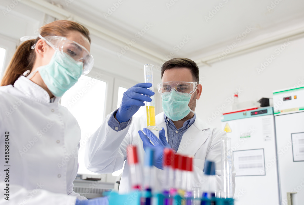 Biologists working in laboratory with chemicals Biologists working in laboratory with chemicals