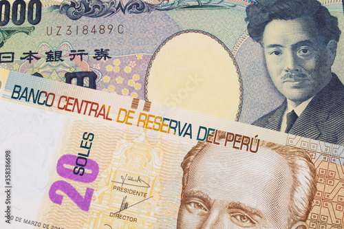 A macro image of a Japanese thousand yen note paired up with a beige, twenty sol bill from Peru. Shot close up in macro.