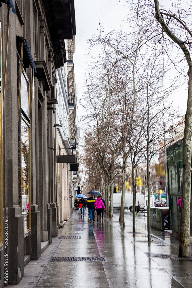 The famous Serrano street on a rainy winter day at Madrid city center in Spain