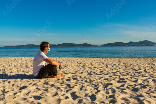 Man with mask on the beach after Covid-19