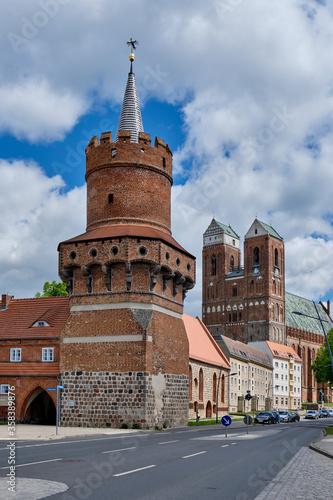 Der Mitteltorturm, Teil der ehemaligen Stadtbefestigung in Prenzlau. Im Hintergrund die Türme der Hauptpfarrkirche St. Marien photo