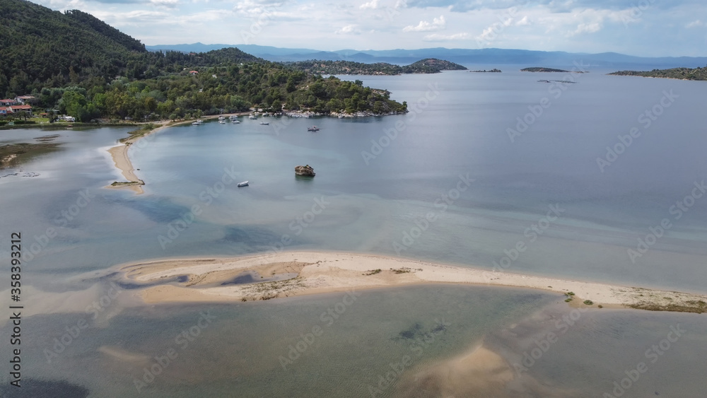 Mediterranean Greek landscape coastal drone shot. Aerial day top view of Sithonia Chalkidiki peninsula above shoreline with green plantation and small, sandy inlet.