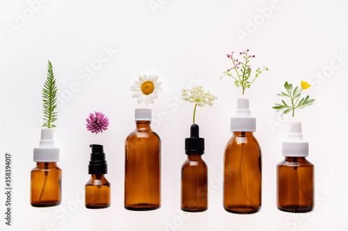 Fototapeta Naklejka Na Ścianę i Meble -  Wild flowers and medicine glass bottle on white background is used for cosmetic skin care product. Concept of natural cosmetics or alternative medicine
