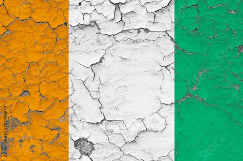 Cote D'Ivoire flag close up grungy, damaged and weathered on wall peeling off paint to see inside surface. Vintage concept. © sezerozger
