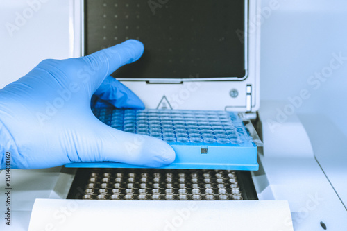 Obraz na płótnie Research scientist putting test 96 well platte into real-time pcr machine w salonie
