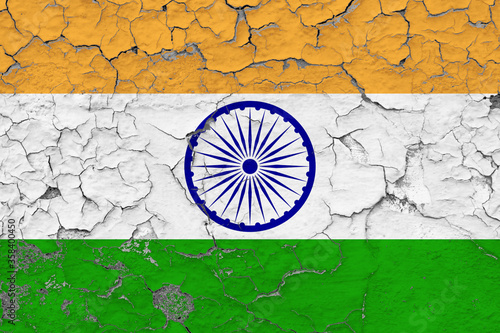 India flag close up grungy, damaged and weathered on wall peeling off paint to see inside surface. Vintage concept.