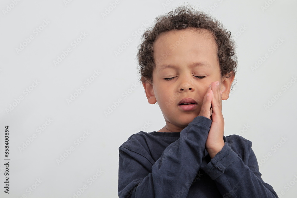 boy praying to God with hands together and closed eyes on white background boy praying to God with hands together and closed eyes on white background