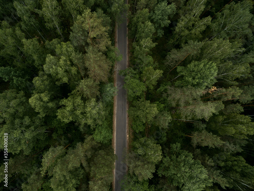 Asphalt road through the green forest. Summer landscape. Top view. Drone photo © evseev_tim