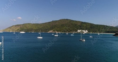 yachts in the bay, against the backdrop of the hilly coast, built on the shore, calm sea