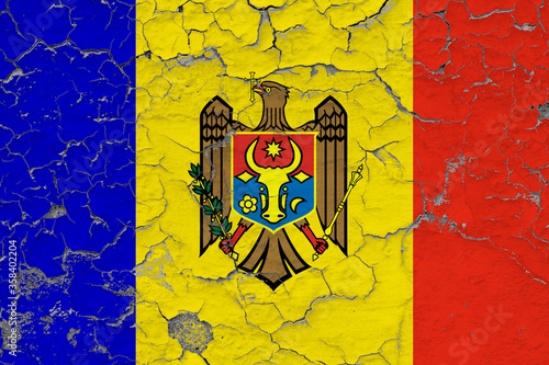 Moldova flag close up grungy, damaged and weathered on wall peeling off paint to see inside surface. Vintage concept.