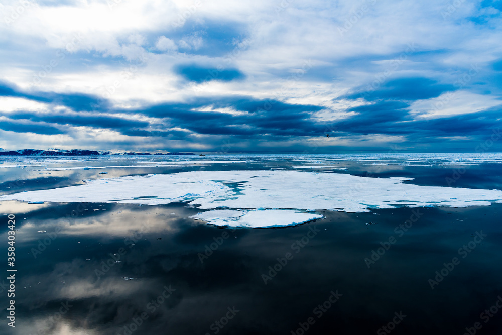 Cloudy sky and Ice pieces on the water in Arctic