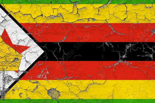 Zimbabwe flag close up grungy, damaged and weathered on wall peeling off paint to see inside surface. Vintage concept. © sezerozger