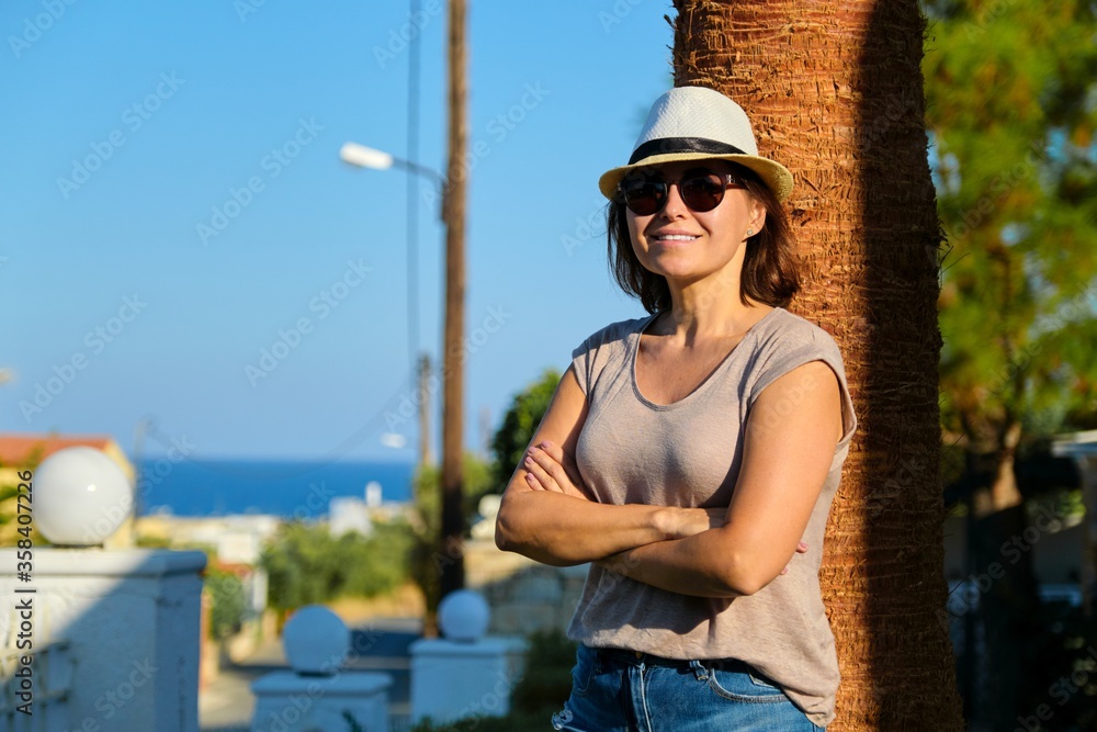 Portrait of mature beautiful smiling woman on vacation, summer tropical landscape