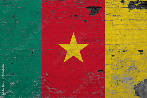 Cameroon flag on grunge scratched concrete surface. National vintage background. Retro wall concept.