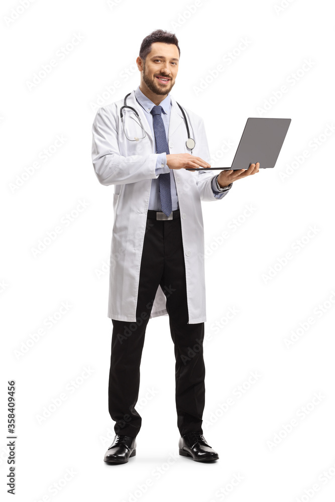 Male doctor standing and using a laptop computer