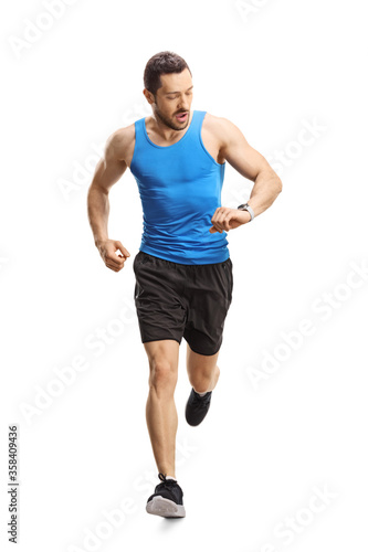 Man in sportswear running towards the camera and looking at his smartwatch