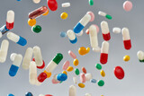 Creative concept with different pills, capsules falling over grey background. Health care, vitamins and treatment concept