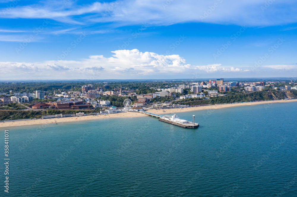 Aerial drone photo of the Bournemouth beach, Observation Wheel and Pier on a beautiful sunny summers day with lots of people relaxing and sunbathing on the British Dorset sandy beach and ocean