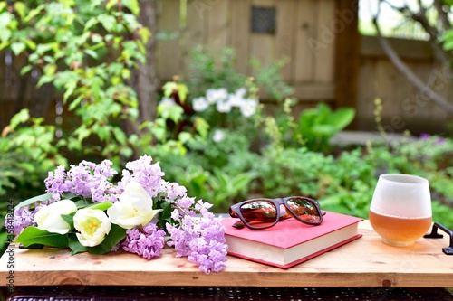 Outdoor relaxing patio in beautiful serene landscaped garden for sitting on a warm summer day with a glass of wine and book during a stay at home vacation during quarantine lockdown