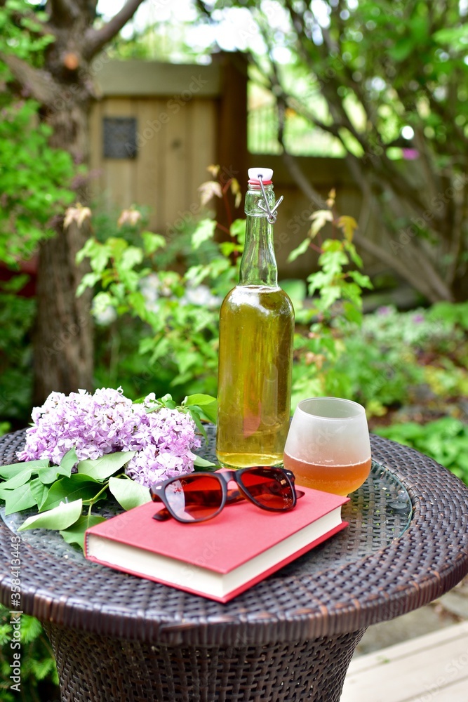 Outdoor relaxing patio in beautiful serene landscaped garden for sitting on a warm summer day with a glass of wine and book during a stay at home vacation during quarantine lockdown Outdoor relaxing patio in beautiful serene landscaped garden for sitting on a warm summer day with a glass of wine and book during a stay at home vacation during quarantine lockdown