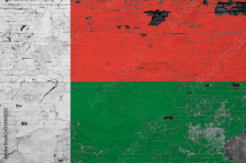 Madagascar flag on grunge scratched concrete surface. National vintage background. Retro wall concept. © sezerozger
