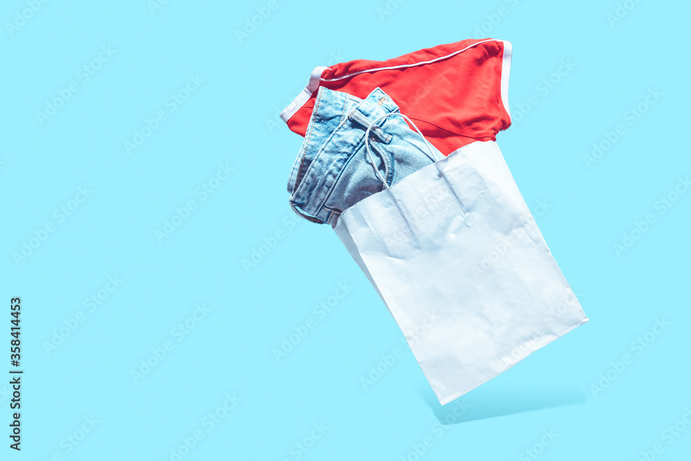Flying shopping paper bag with purchases. Concept of consumerism, ease of shopping. Copy space trend pastel colors. Flying shopping paper bag with purchases. Concept of consumerism, ease of shopping. Copy space trend pastel colors.
