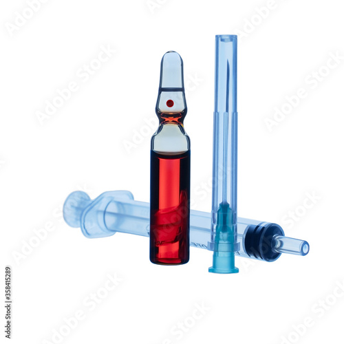 A medicine ampoule with red liquid, a needle and syringe isolated on white