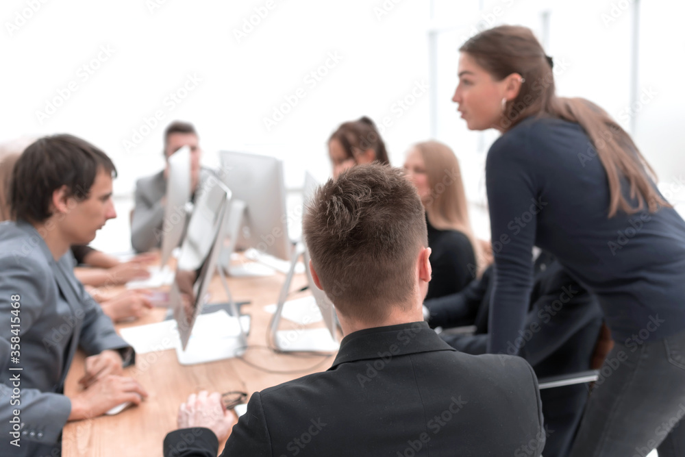 young employee sitting at a Desk about looking at the camera. young employee sitting at a Desk about looking at the camera.