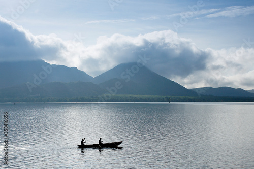 Fishermen in an outrigger dugout canoe on the waters of Kandalama Tank (Lake Kandalama), Sri Lanka