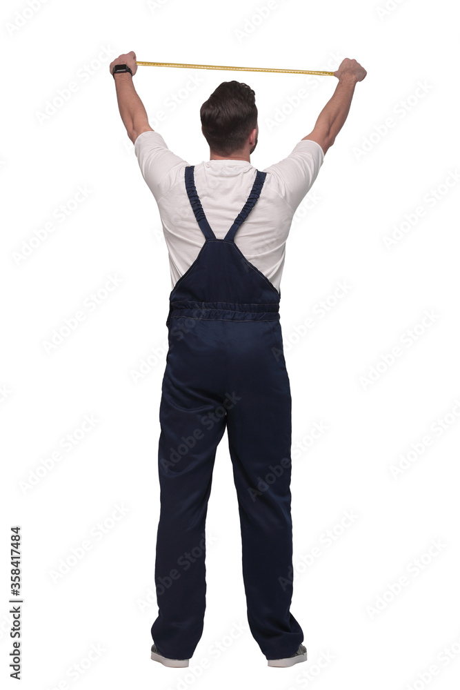 rear view. a man measuring something with a construction tape measure. rear view. a man measuring something with a construction tape measure.