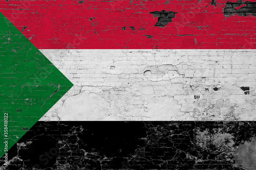Sudan flag on grunge scratched concrete surface. National vintage background. Retro wall concept.
