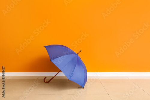 Stylish umbrella near color wall