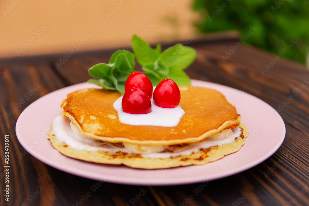 pancakes with yogurt lie on a plate on a wooden background pancakes with yogurt lie on a plate on a wooden background