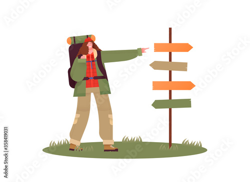 Woman pointing at guidepost with camping backpack