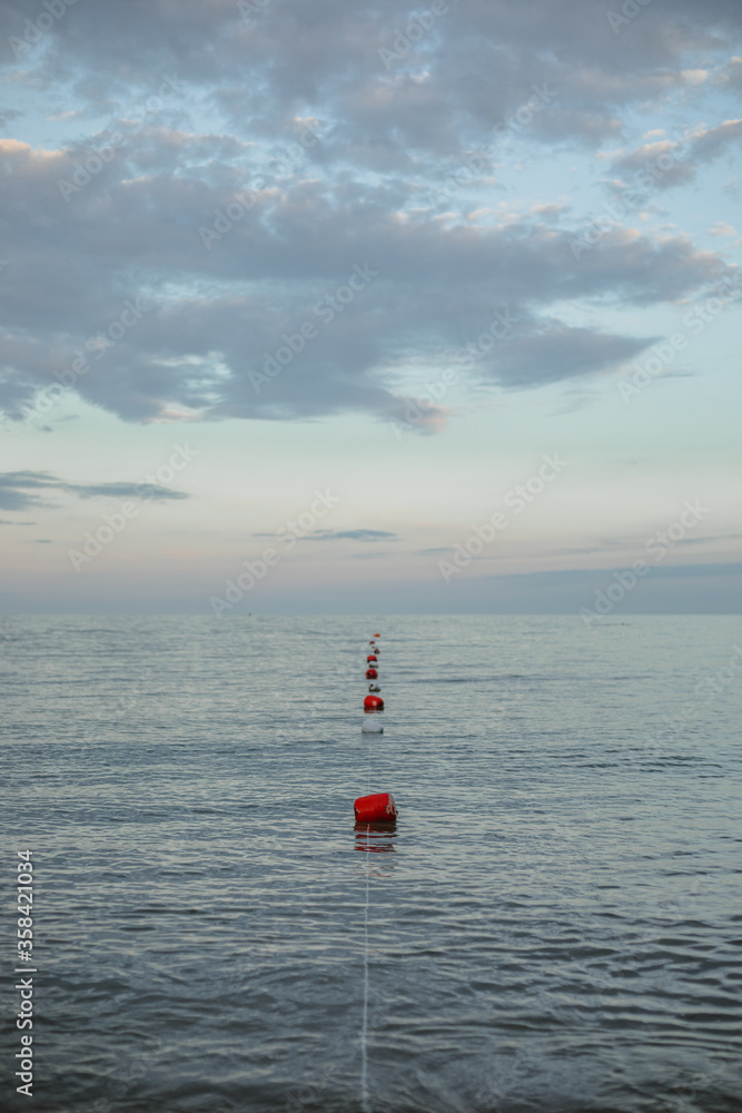 Strip of red and white buoys on the surface of the sea
