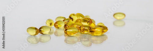 Beautiful yellow transparent pills closeup on white background. Medical concept