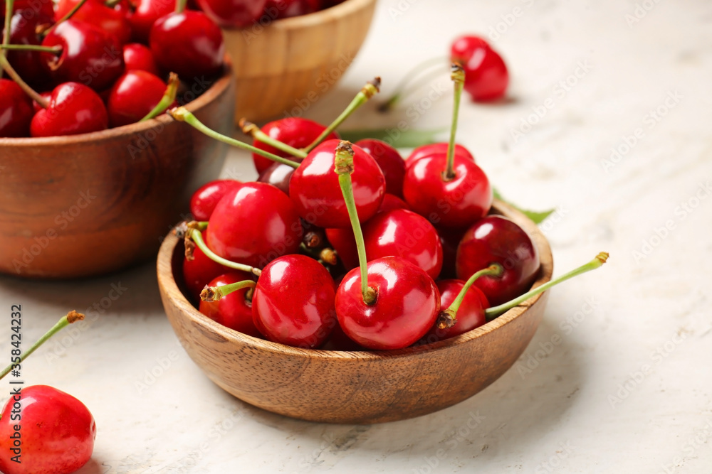 Bowls with sweet cherry on light background Bowls with sweet cherry on light background