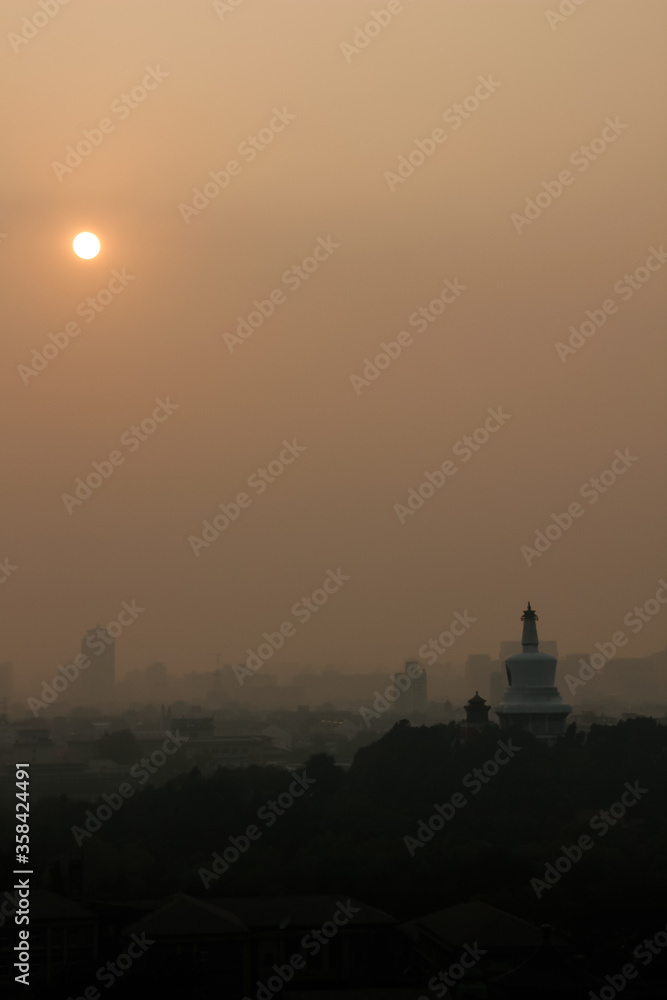 Sunset in Beijing, with the famous skyline and the White Pagoda, during a hot and polluted summer Sunset in Beijing, with the famous skyline and the White Pagoda, during a hot and polluted summer