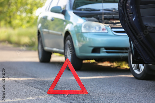 Emergency stop sign near broken cars after accident on road