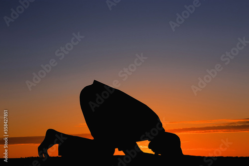 Silhouette of Muslim man praying at sunset. Holy month of Ramadan