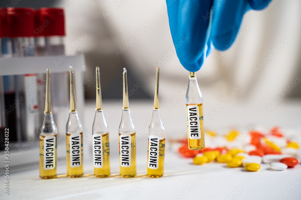 Medical worker in blue gloves takes Vaccine in ampoule of Vaccine. Vaccine and syringe injection, immunization and treatment from COVID-19 Medical worker in blue gloves takes Vaccine in ampoule of Vaccine. Vaccine and syringe injection, immunization and treatment from COVID-19