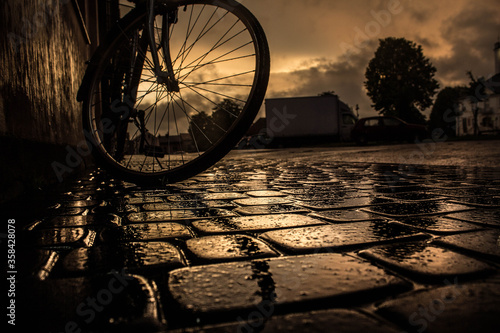 Night rainy city. Paving stones. Wet streets. Bike at sunset. The world is wonderful. Background.