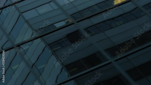 MONTREAL, CANADA - MARCH 14 2019 Dutch angle traveling shot from street view of reflective glass skyscraper ending in a wall of white reflected windows.