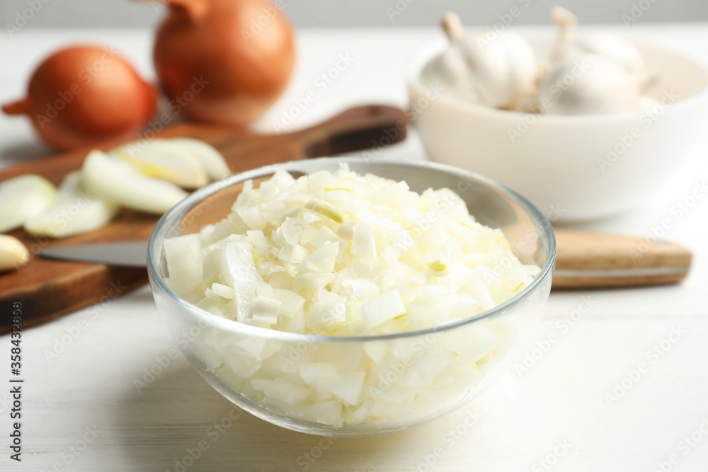Chopped onion in bowl on white wooden table Chopped onion in bowl on white wooden table
