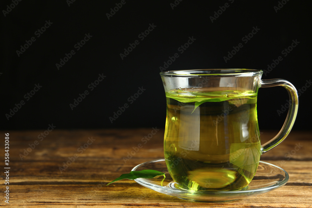 Cup of aromatic green tea on wooden table. Space for text Cup of aromatic green tea on wooden table. Space for text